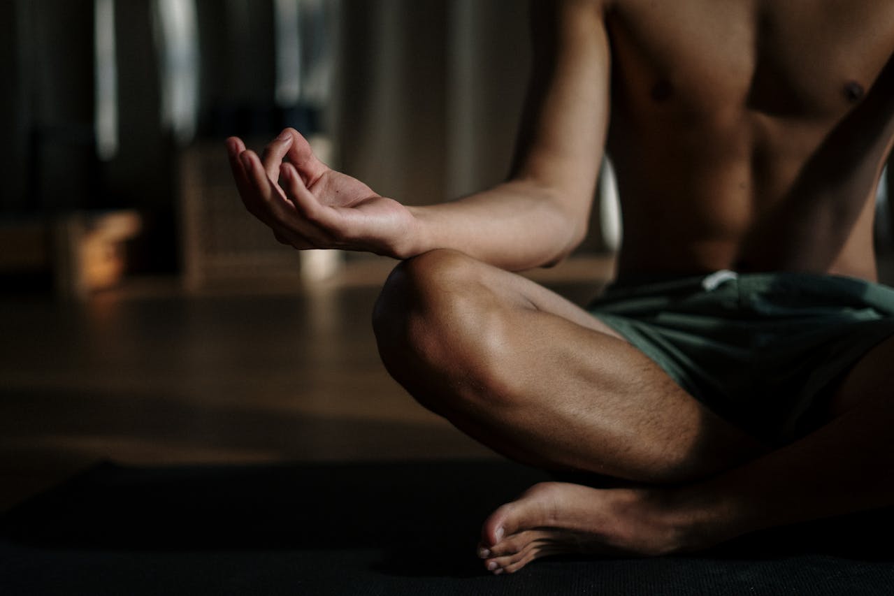 Close-up of a person sitting cross-legged in a meditation pose.