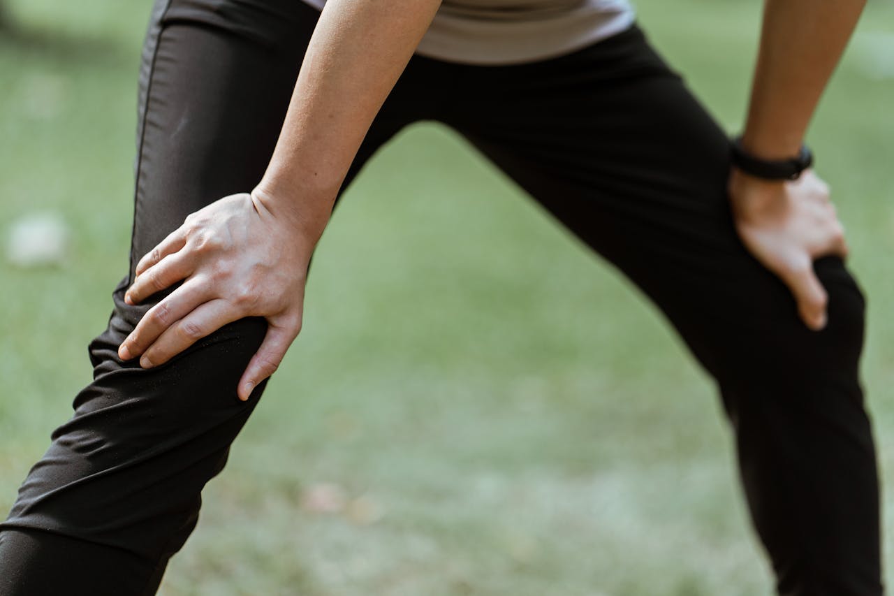 Person holding their knees while stretching—demonstrating the importance of joint health and mobility.