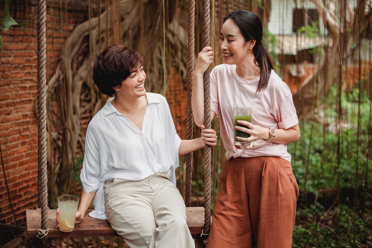 Two women enjoying refreshing drinks outdoors.